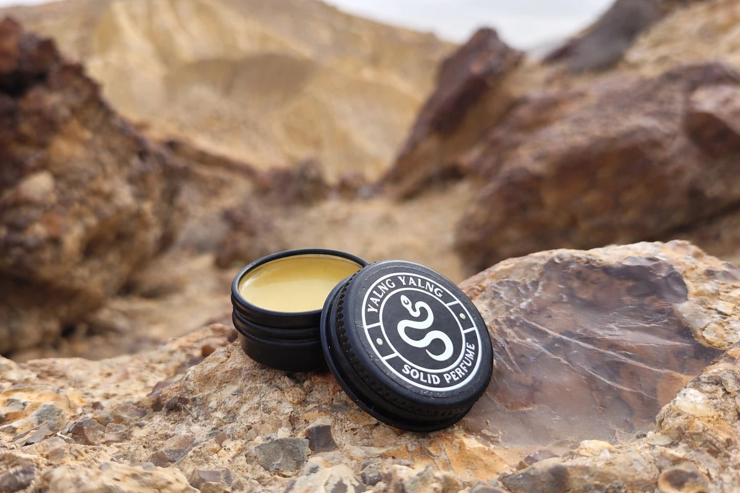 Pine resin and ylang ylang solid botanical perfume in a black tin, natural handmade plant-based fragrance