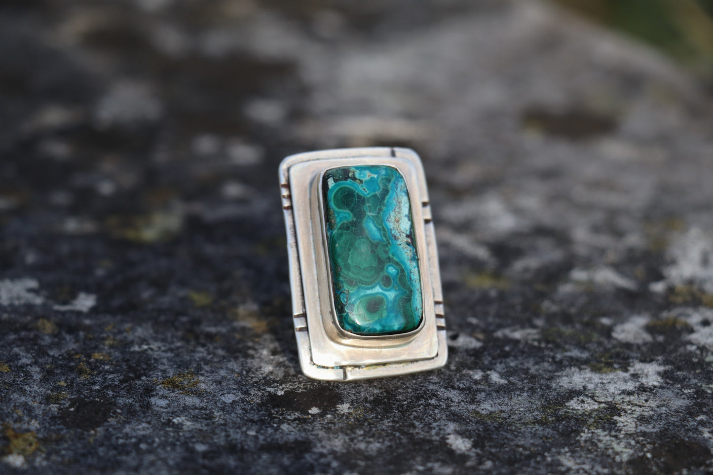 Front view of a large Chrysocolla Malachite ring set in sterling silver, highlighting the rectangular natural stone with deep teal and green swirls. Bold statement crystal ring for emotional healing.