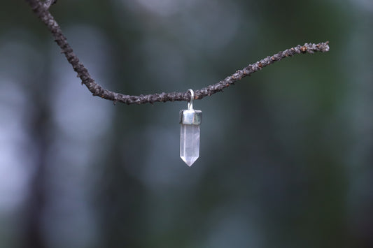 Handcrafted Quartz Healing Crystal pendant on a branch, perfect for Meditation and Energetic Cleansing.