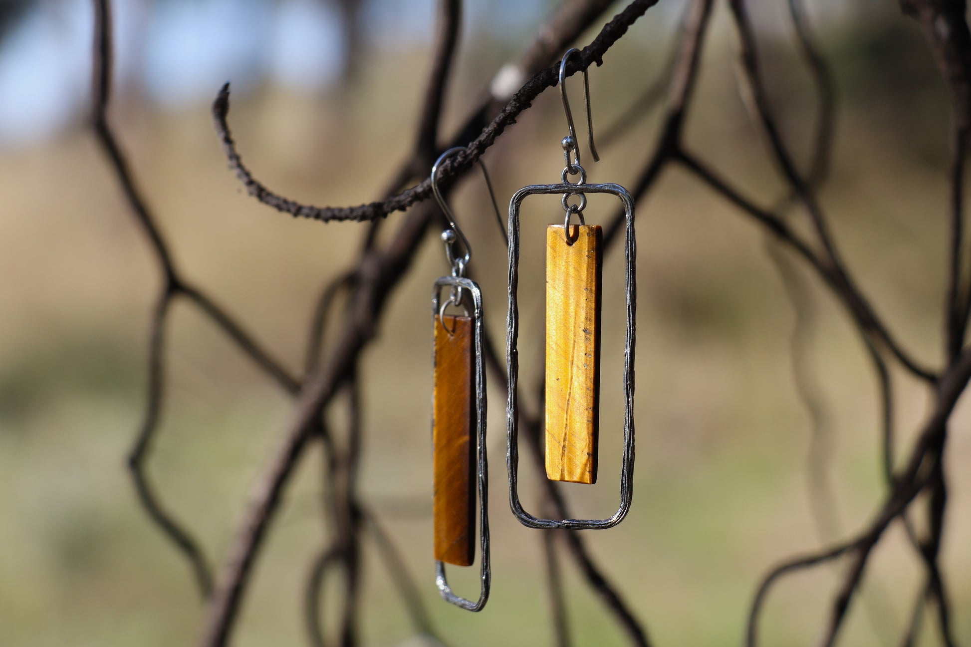 Handcrafted Silver Earrings with Tiger's Eye promoting protection and emotional resilience.