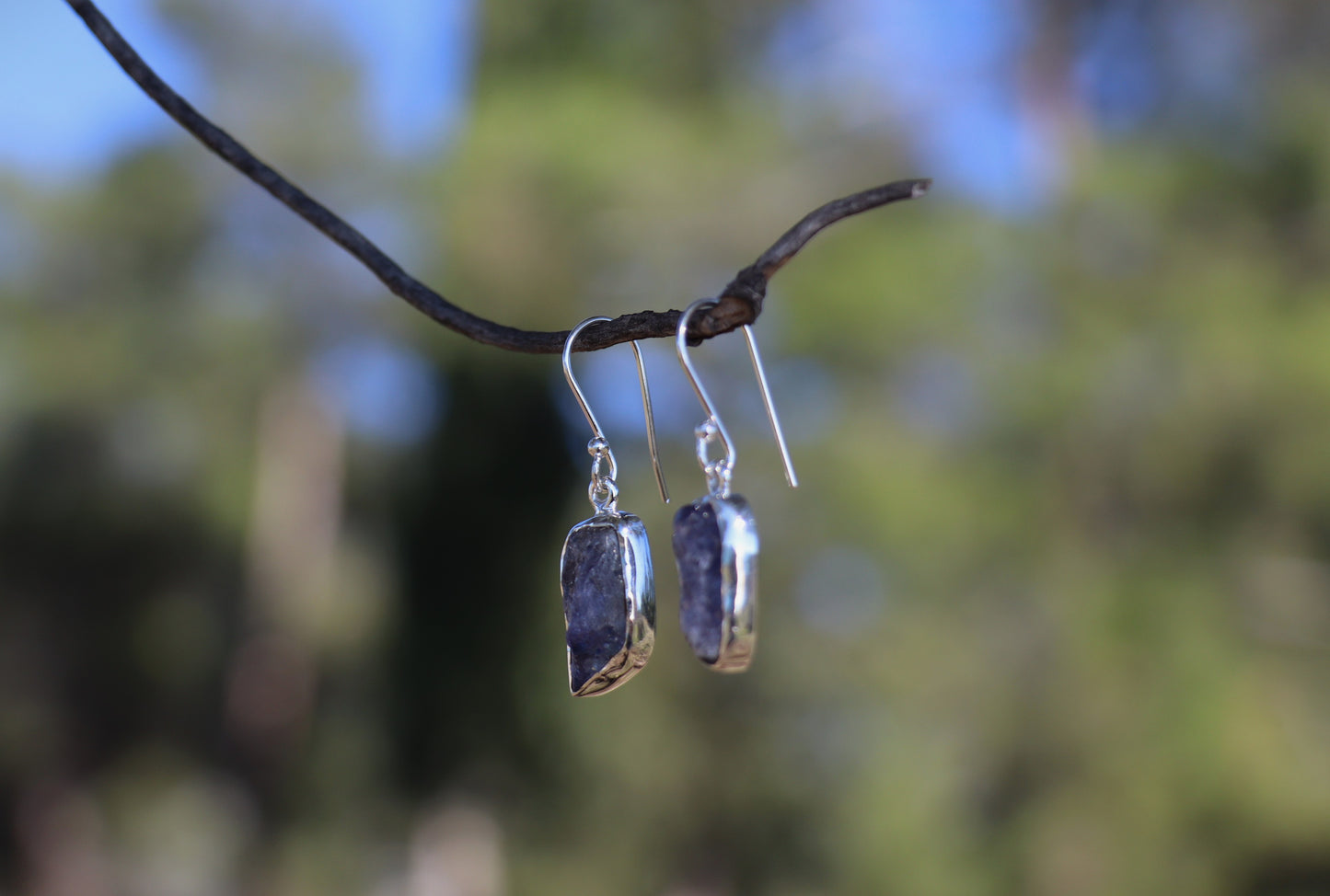 Natural raw amethyst gemstone earrings with sterling silver hooks, artisan purple crystal jewelry photographed outdoors