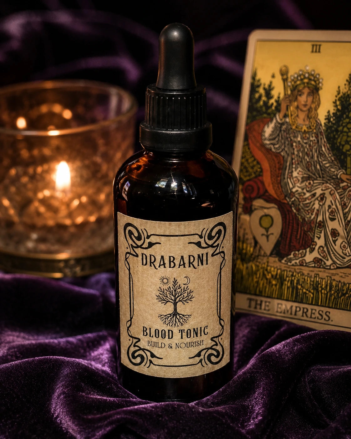 Drabarni Blood Tonic mineral-rich herbal tincture for postpartum recovery, fatigue, and burnout on a mystical purple velvet background. Formulated by a green witch herbalist to support chronic fatigue, hair loss, and dizziness while rebuilding the body's core vital essence and grounding the spirit.