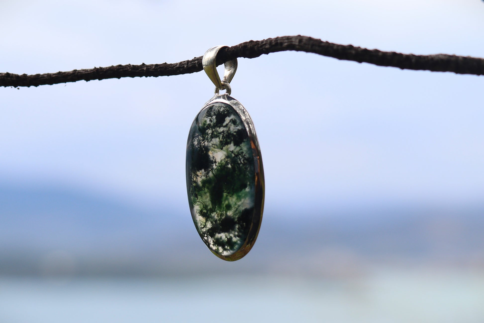 Handcrafted Silver Pendant with Moss Agate promoting emotional balance and connection to nature.