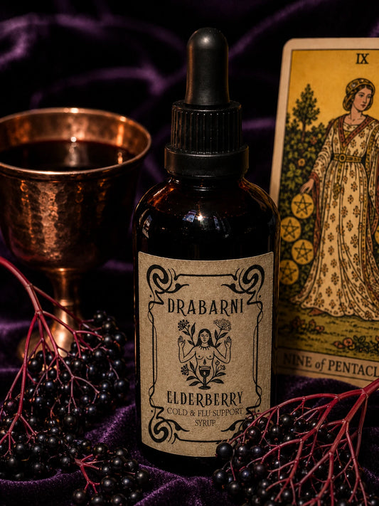 Drabarni organic Elderberry syrup for kids and adults immune support against cold and flu. A potent antiviral elderberry liquid medicine blended with turkey tail mushroom, echinacea, and turmeric. Handcrafted by a green witch apothecary for seasonal wellness on a purple velvet altar.