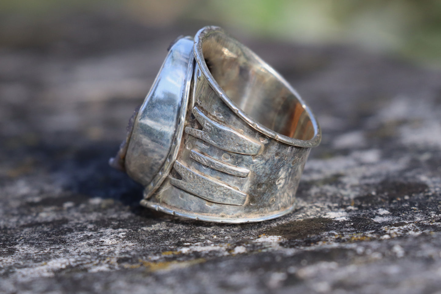 Close-up of large purple druzy gemstone set in wide sterling silver ring, handmade bohemian druzy quartz jewelry.