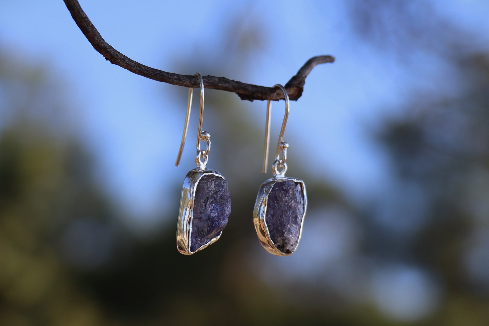 Handcrafted raw amethyst dangle earrings in 925 sterling silver hanging from a branch, natural purple gemstone jewelry